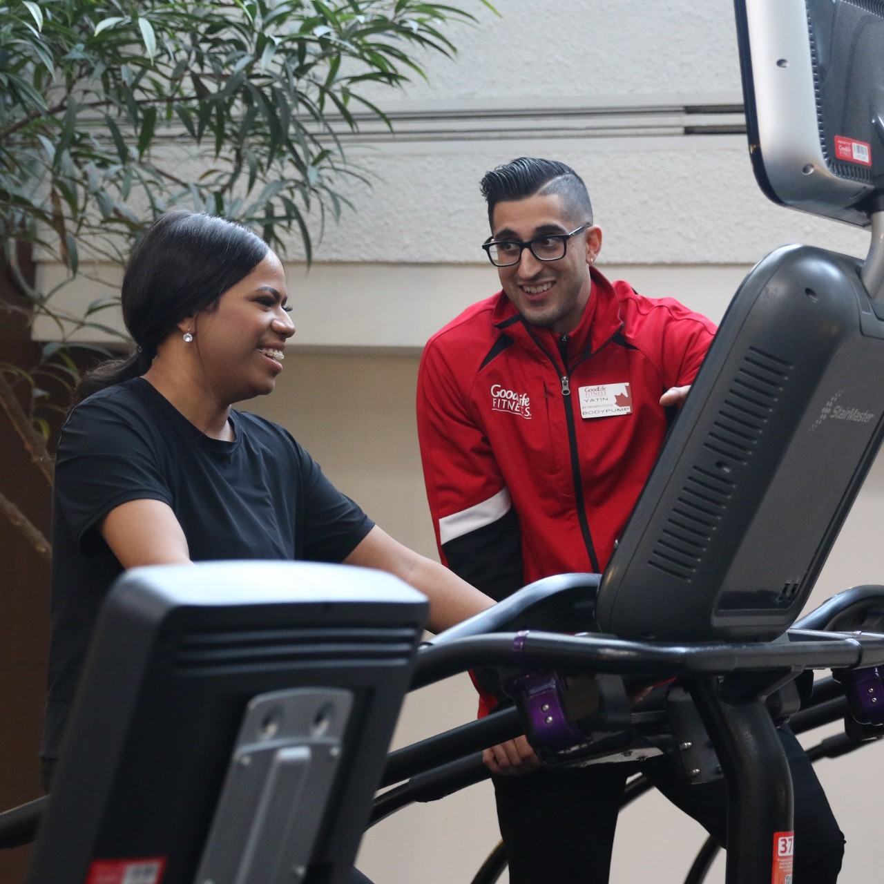 A Personal Trainer assisting a Member on the cardio equipment at GoodLife